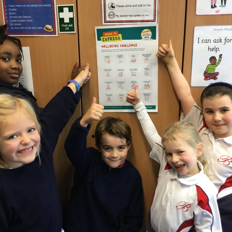 students with thumbs up at a wellbeing poster